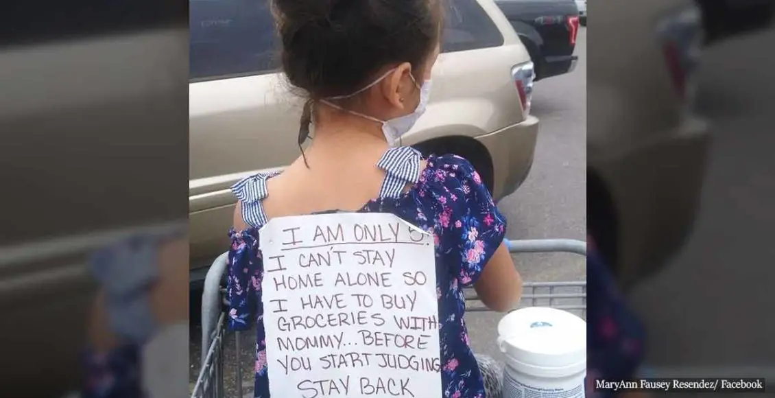 5-year-old girl wears a sign while 'essential-shopping' with her mom so they won't be shamed