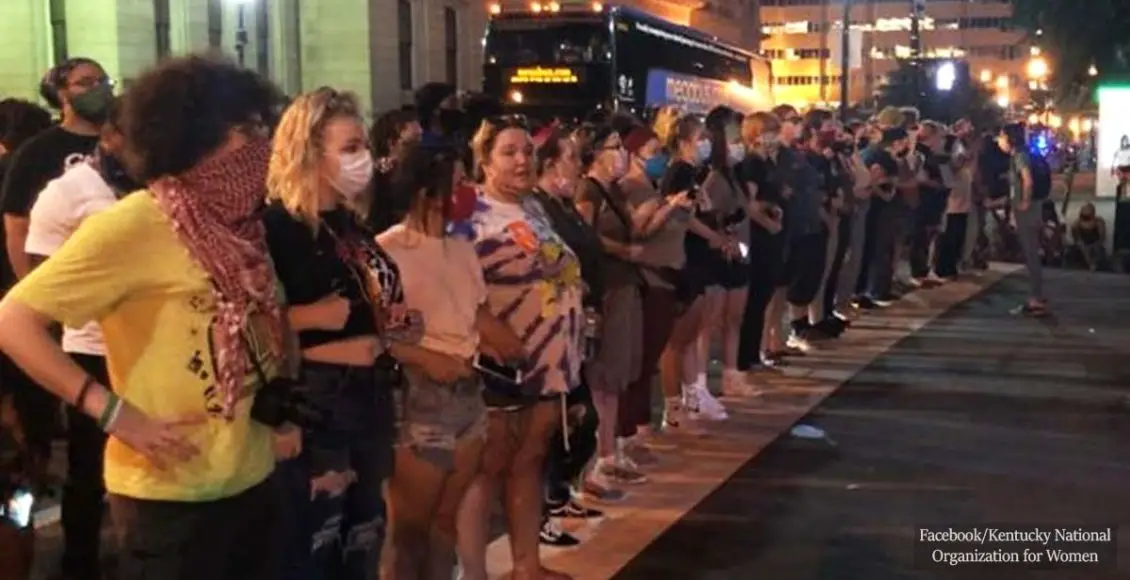 White women form an arm-in-arm shield to protect black protesters at the Louisville Metro Police